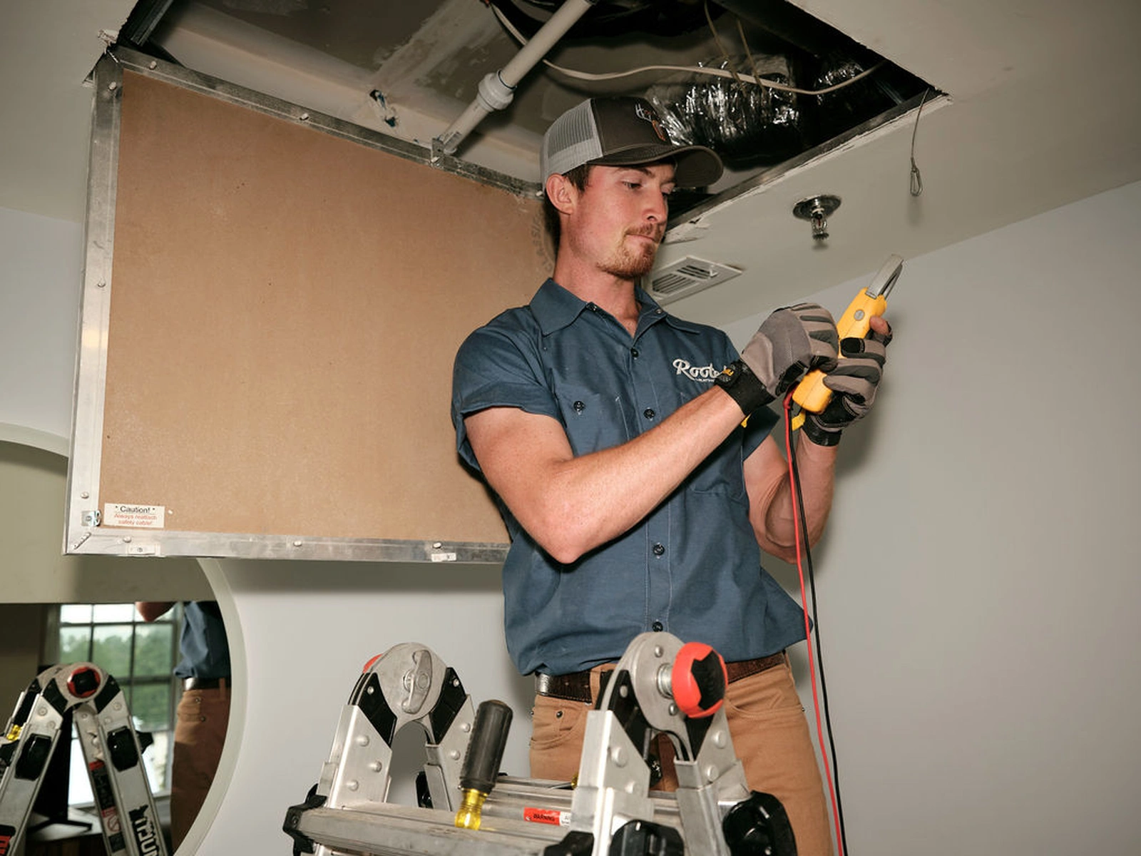 AC repair service technician working on ceiling ducts and tools