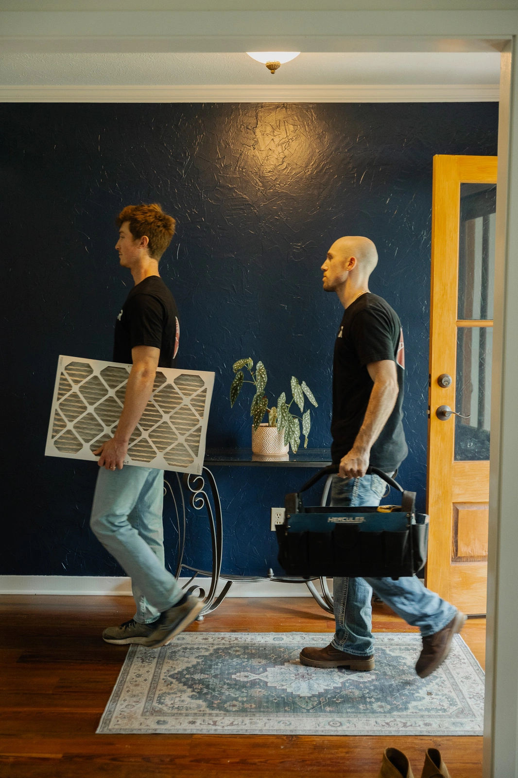 Rooted Heating & Air technicians carrying tools and filters