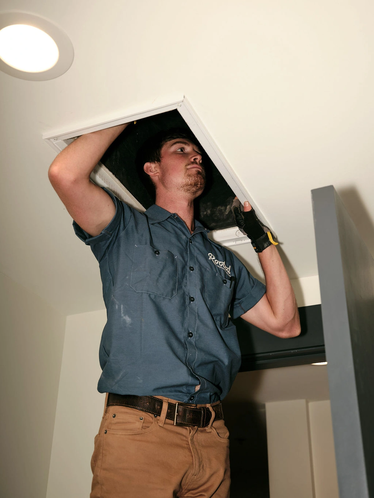 Heating repair service technician working on ceiling unit