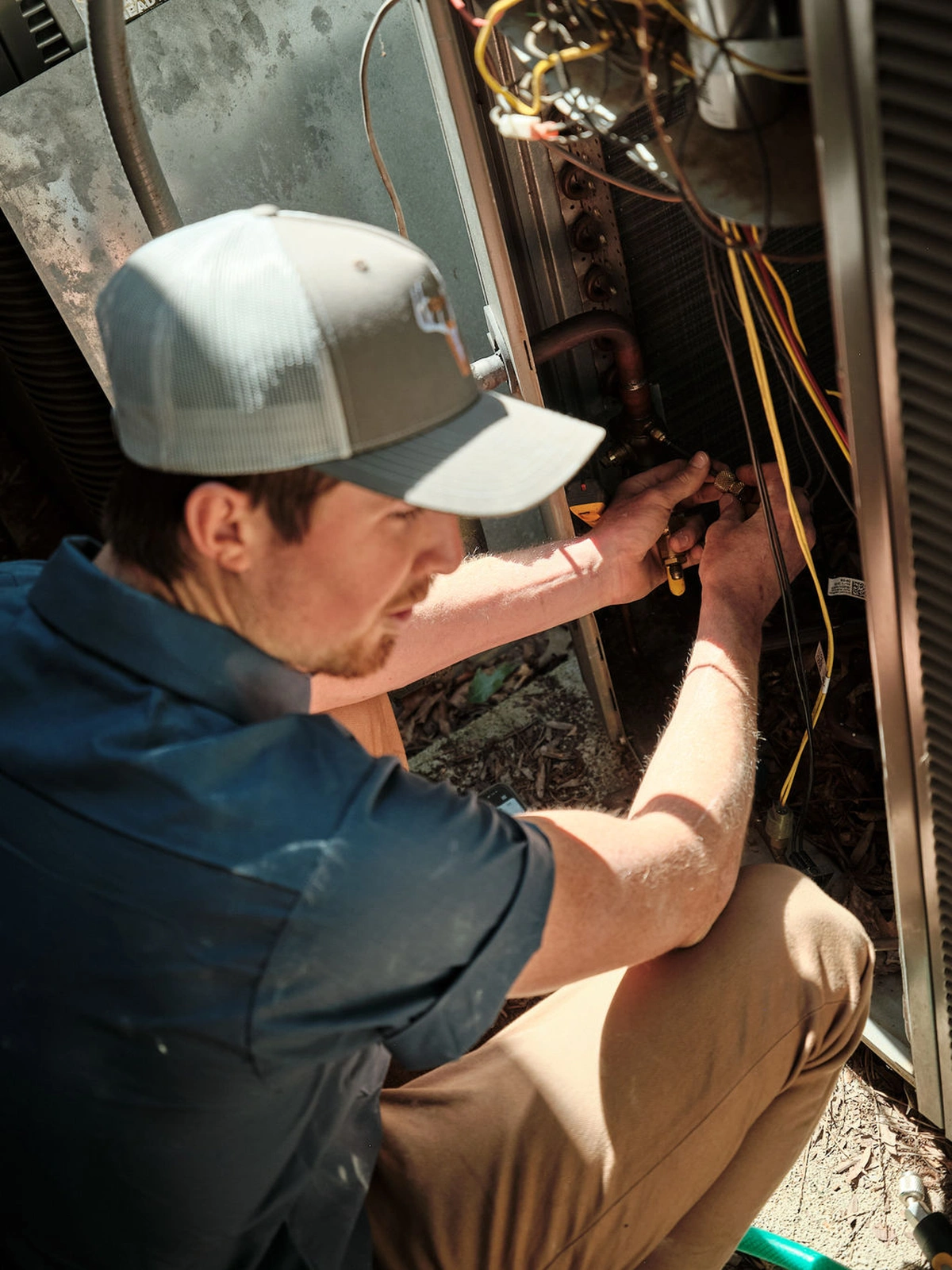 Technician charging an air conditioning unit with gauges