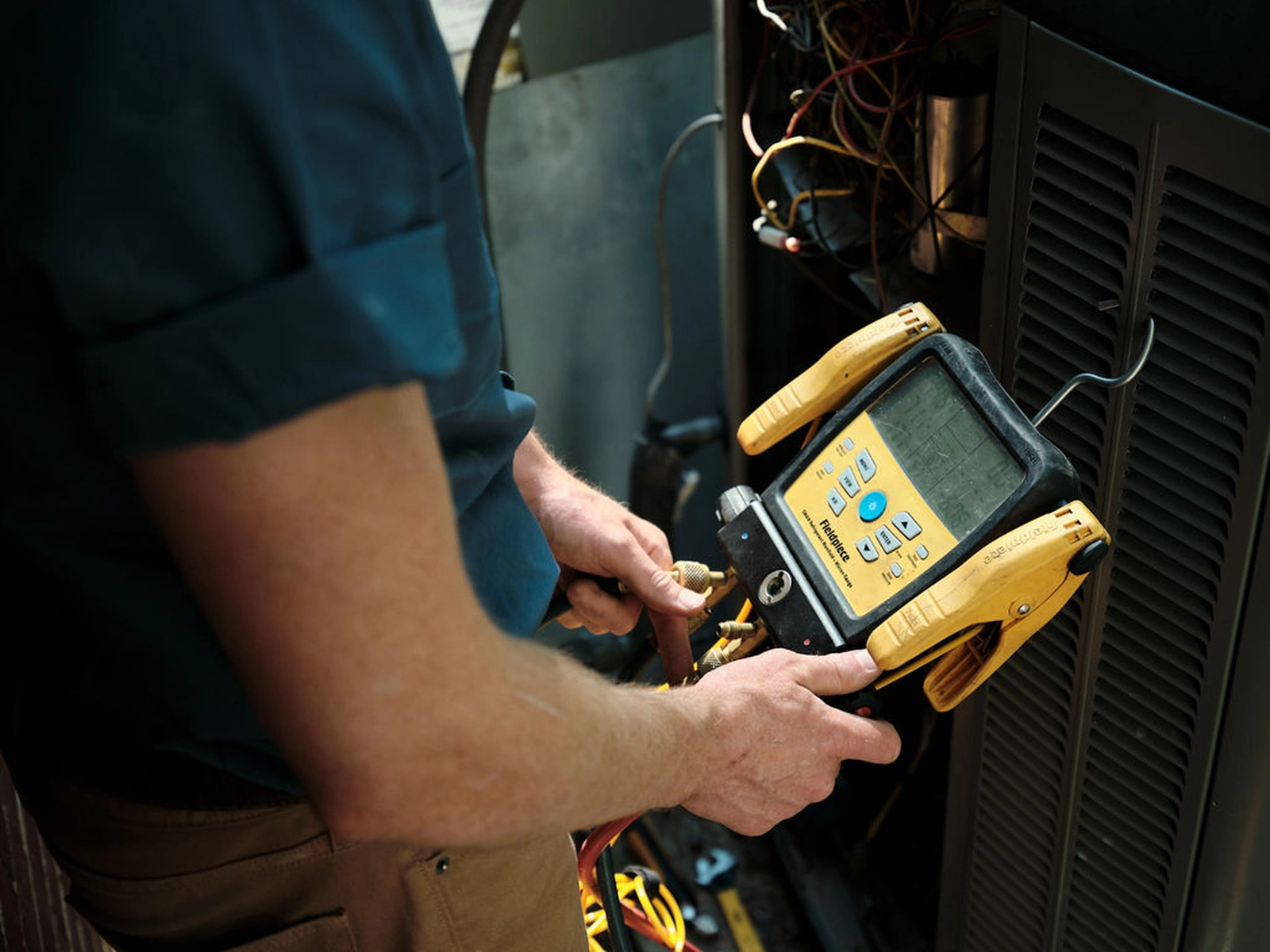 Rooted Heating & Air service technician using diagnostic tools