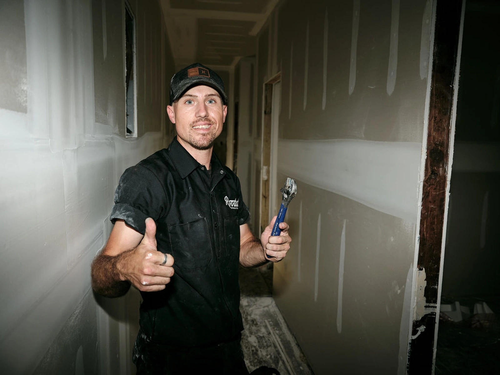 Ian, Rooted Heating & Air HVAC technician, smiling in a hallway